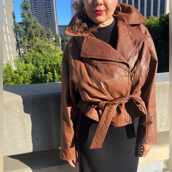 Vintage Brown leather moto jacket with zipper closure and belt detail.